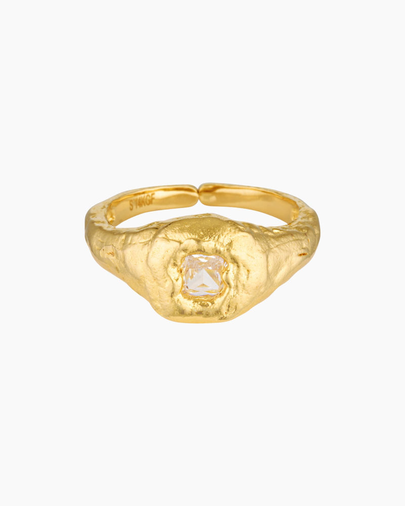 Close-up product image of a gold filled ring featuring a textured organic band with a central clear crystal set in a raised bezel on a white background. This image is for women looking for an everyday gold ring that adds subtle statement detail and offers a refined alternative to smooth minimalist bands.