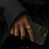 dark aesthetic photo of a gold filled ring ith white gemstone 