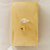 handmade organic textured gold filled ring and one organic shaped ring in silver with white gemstone on a butter stick