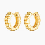 Pair of Xanthe textured gold huggie hoop earrings on a white background, featuring a sculptural rippled wave design. Designed for women seeking small gold hoop earrings that add subtle statement and texture to everyday styling, ear stacks, and huggie piercings. Ideal for those looking for lightweight, vintage-inspired gold hoops with a refined finish for daily wear.