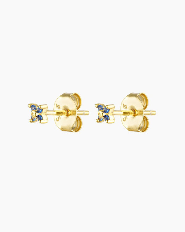A pair of small, dainty flower earrings with a gold plating and blue zirconia crystals, designed for sensitive skin.