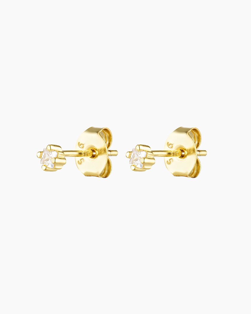 Product image of a pair of gold stud earrings featuring a small clear crystal set in a classic prong setting with butterfly back closures, displayed on a white background. Designed for women seeking minimalist gold stud earrings for sensitive ears, these delicate crystal studs offer a lightweight, everyday solution for first piercings or additional lobe piercings, providing subtle sparkle, comfort, and timeless versatility for daily wear or special occasions.