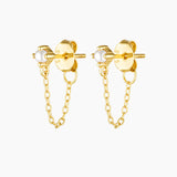Studio product image of the Assana pearl stud earrings in gold, featuring small white pearl studs set on a solid sterling silver base with long-lasting 18k micron gold plating and a delicate gold chain connecting the stud to the butterfly backing. Designed for adults seeking minimalist pearl earrings, chain stud earrings, or hypoallergenic gold jewellery for sensitive ears, these earrings offer a secure, lightweight option that adds subtle movement and elegance to everyday wear, layered ear stacks, and refi