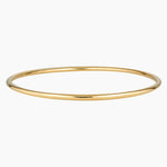 Minimalist slim gold bangle bracelet photographed on a white background, featuring a smooth polished finish and thin circular profile in 14K gold filled. Designed for women seeking a timeless everyday gold bracelet that layers easily with other bangles or can be worn alone for a clean, understated look. Ideal for those looking for durable, low-maintenance gold jewellery that is water safe, lightweight, and suitable for daily wear.