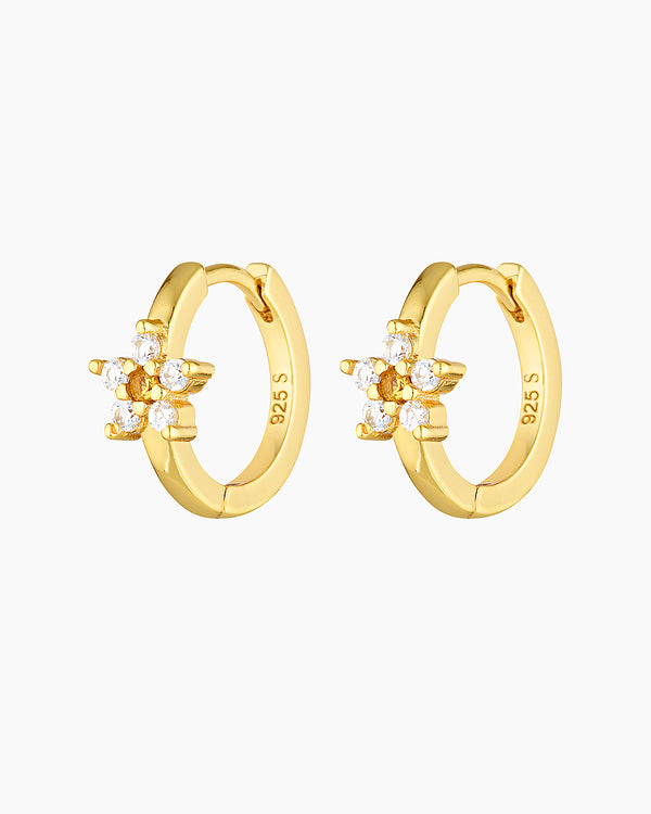 Pair of gold daisy hoop earrings photographed on a white background, featuring a small 14mm gold hoop with a floral charm made of clear cubic zirconia petals and a yellow cubic zirconia centre. Designed for women seeking delicate gold flower earrings, these dainty hoop earrings showcase fine detail, sparkle, and compact sizing for everyday wear. Ideal for upper lobe or second piercings, they help solve the need for lightweight, elegant jewellery that adds subtle colour and femininity without overpowering 