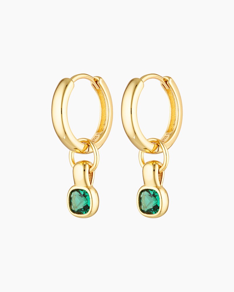 Pair of small gold hoop earrings with removable emerald green cubic zirconia charm, photographed on a white background. The earrings feature polished 18K gold-plated hoops with a dangling rectangular emerald-style stone. Designed for women seeking versatile everyday gold hoop earrings that add subtle colour, movement, and refined birthstone detail while remaining lightweight and wearable for daily styling.