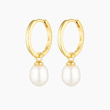 Elegant pair of gold pearl hoop earrings displayed on a clean white background, featuring smooth polished hoops with a dangling genuine freshwater pearl charm. Designed for women seeking minimalist pearl jewellery that works for everyday wear, weddings, bridal styling, or special occasions. These lightweight, hypoallergenic pearl hoop earrings offer a refined solution for adding softness and elegance to an ear stack without overpowering an outfit, making them ideal for those who want timeless hoops
