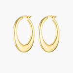 Product photo of a pair of medium-sized gold hoop earrings with a softly sculpted, rounded silhouette and polished finish, shown on a clean white background. The earrings feature a smooth hinged closure and a warm gold tone, highlighting their refined shape and subtle thickness. Designed for women seeking elegant gold hoop earrings that make an impact without feeling heavy, this image showcases statement hoops suitable for occasions, elevated everyday wear, and sensitive ears. Ideal for customers looking fo