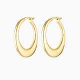 Product photo of a pair of medium-sized gold hoop earrings with a softly sculpted, rounded silhouette and polished finish, shown on a clean white background. The earrings feature a smooth hinged closure and a warm gold tone, highlighting their refined shape and subtle thickness. Designed for women seeking elegant gold hoop earrings that make an impact without feeling heavy, this image showcases statement hoops suitable for occasions, elevated everyday wear, and sensitive ears. Ideal for customers looking fo