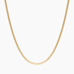 Product-only image of an 18K gold-filled snake chain necklace displayed in a smooth U-shape against a clean white background. The flat, polished snake chain design highlights a sleek, minimalist gold choker that sits flush on the chest. Designed for women seeking a timeless gold snake chain necklace that offers a refined statement look and solves the need for a versatile, everyday piece that can be worn alone or layered.