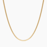 Product-only image of an 18K gold-filled snake chain necklace displayed in a smooth U-shape against a clean white background. The flat, polished snake chain design highlights a sleek, minimalist gold choker that sits flush on the chest. Designed for women seeking a timeless gold snake chain necklace that offers a refined statement look and solves the need for a versatile, everyday piece that can be worn alone or layered.