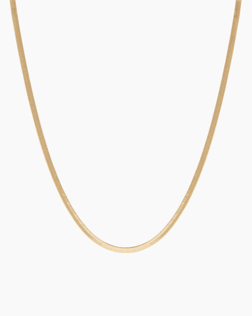 Product-only image of an 18K gold-filled snake chain necklace displayed in a smooth U-shape against a clean white background. The flat, polished snake chain design highlights a sleek, minimalist gold choker that sits flush on the chest. Designed for women seeking a timeless gold snake chain necklace that offers a refined statement look and solves the need for a versatile, everyday piece that can be worn alone or layered.