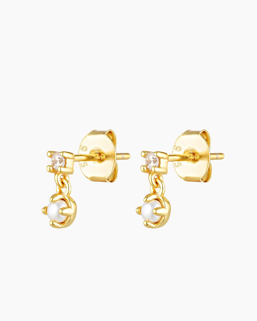 Gold pearl and cubic zirconia stud earrings shown on a white background, featuring a small crystal stud with a dangling freshwater pearl charm in polished 18k gold plating. Designed for women seeking elegant pearl stud earrings that are lightweight, hypoallergenic, and suitable for everyday wear, work, weddings, and sensitive ears, offering a refined solution for minimalist styling and timeless jewellery layering.